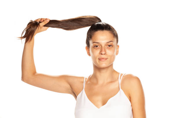 istock Young woman without makeup, holding her panytail on white background 1189321514