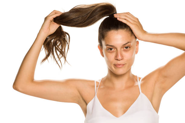 istock Young woman without makeup, holding her panytail on white background 1189321521