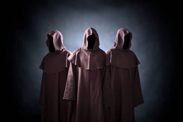 istock Group of three scary figures in hooded cloaks 1189321776