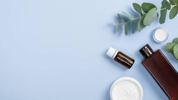istock Top view SPA organic cosmetic products with eucalyptus leaves on pastel blue background. Flat lay essential oil bottle, natural lotion container, face cream. Natural organic beauty product concept 1189321807