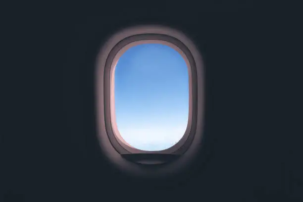 Airplane window. Glass in focus sky blurry.