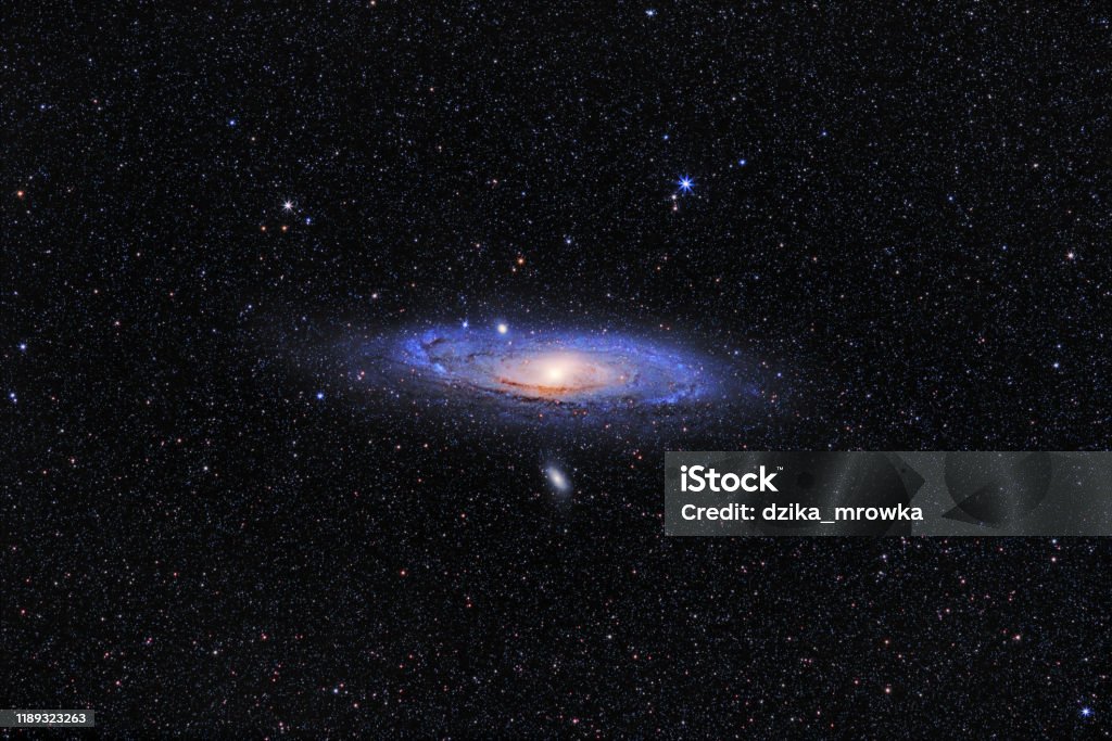 Andromeda Galaxy (M31) and its satellite galaxies (M32 and M110) in Andromeda constellation against widefield starry sky Andromeda Galaxy Stock Photo