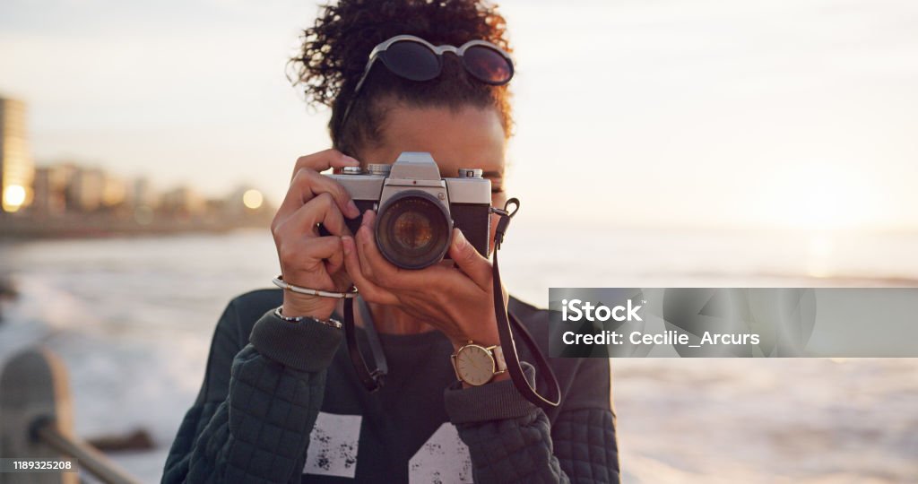I haven't come across something I can't photograph Cropped shot of an attractive young woman standing alone in the city and taking a picture with her camera African-American Ethnicity Stock Photo