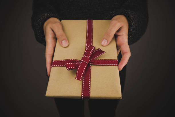 istock Woman with dark sweater holding a gift. 1189325831