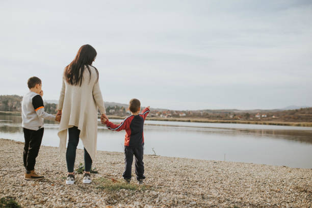 istock Mother with her sons walking by the lake 1189327752