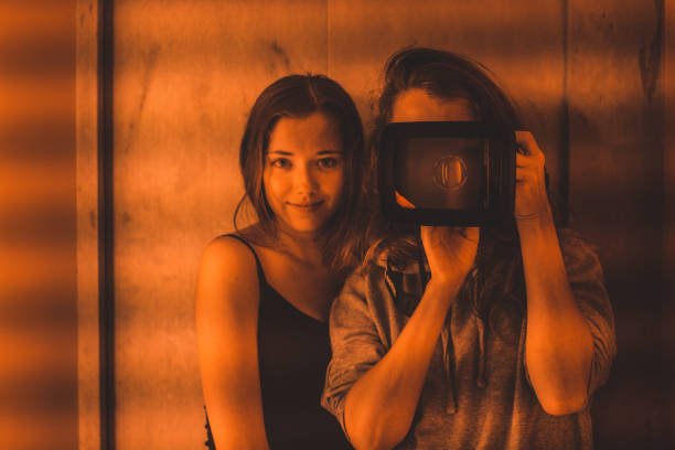 Two women take a picture in the mirror