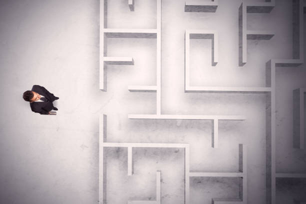 istock Confused businessman standing at a maze wall 1189332995