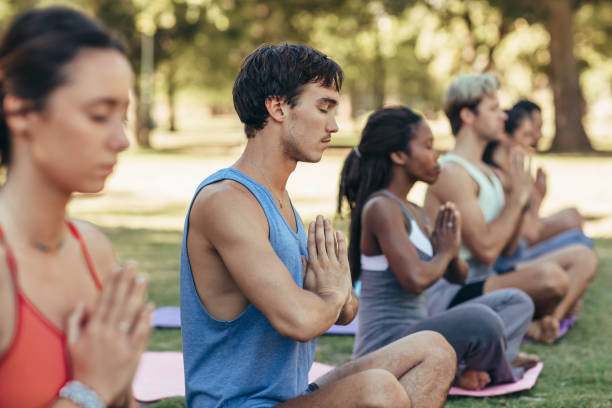 istock Young man meditating during an outdoor yoga class 1189333236