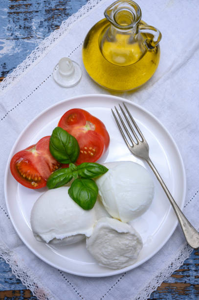 istock Cheese collection, organic mozzarella soft cheese served with ripe tomato and fresh green basil 1189334751