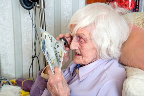 istock Elderly visually impaired woman with magnifyer loupe. 1189335849