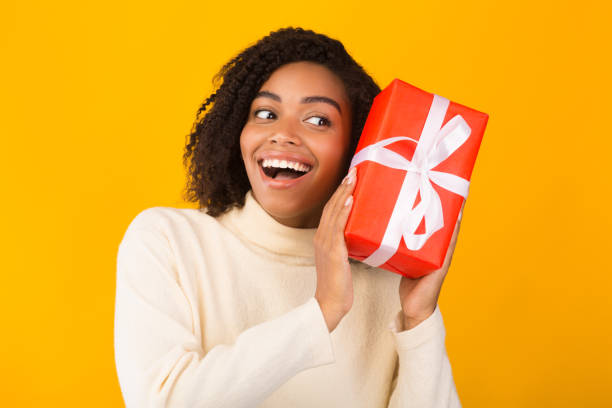 istock Excited black girl holding new year gift 1189336876