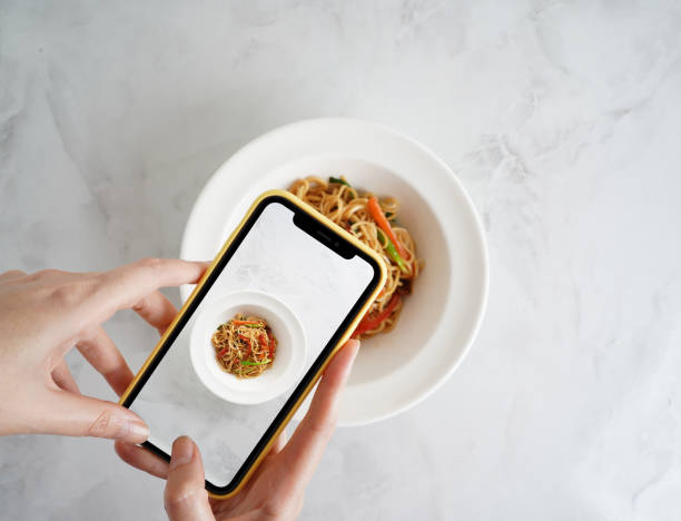 mujeres influencer que toman una foto de comida con su teléfono - alimento fotos fotografías e imágenes de stock