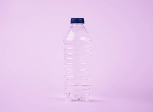 Water in plastic bottle on isolated pink background