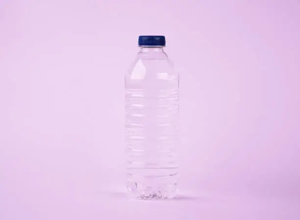 Photo of Water in plastic bottle on isolated pink background