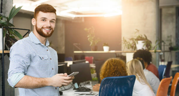 istock Friendly caucasian man with cellphone smiling at camera 1189338403