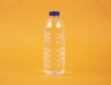 Water in plastic bottle on isolated yellow background