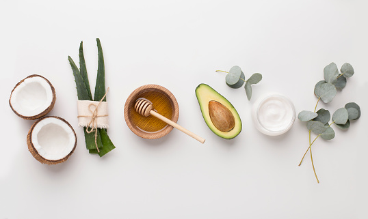 Medical plants used in alternative cosmetology: aloe, honey, coconut and avocado, white background, panorama