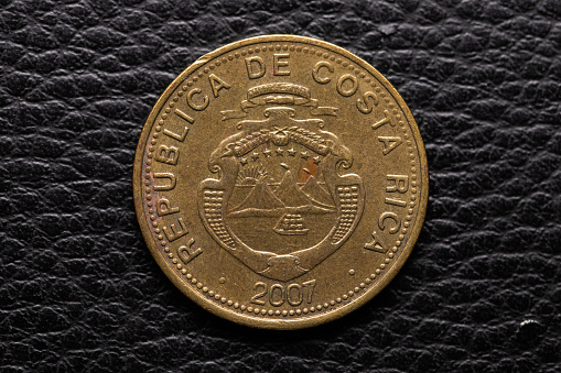 Costa rican coin on black leather