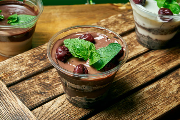 istock Vegetarian healthy dessert trifle with chocolate and cherry in a plastic container on a wooden background 1189344132