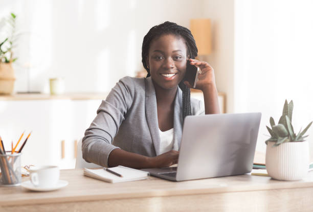 istock Smiling african female manager talking on cellphone consulting client 1189346450