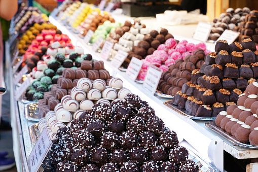 Assortment of delicious chocolate candies for sale on counter of shop, market, cafe. Variety of marzipan candyballs on the store shelves.