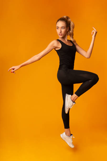 istock Fit Lady Jumping During Workout Over Yellow Background 1189346462