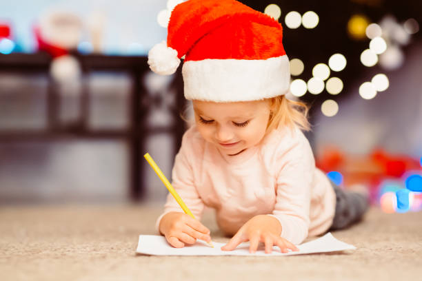 ragazzina concentrata che scrive lettera a babbo natale - pensive only baby girls baby girls baby foto e immagini stock