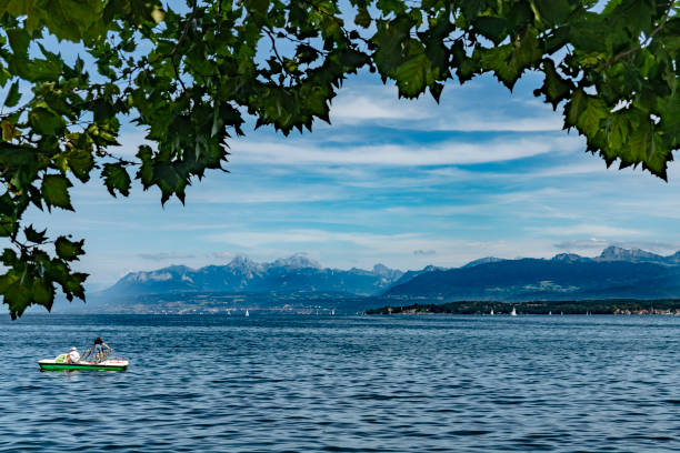 Pedal boat on Lake Geneva, Switzerland.  This is a hired boat with tourists in front of the Alps mountain range across Lake Geneva.