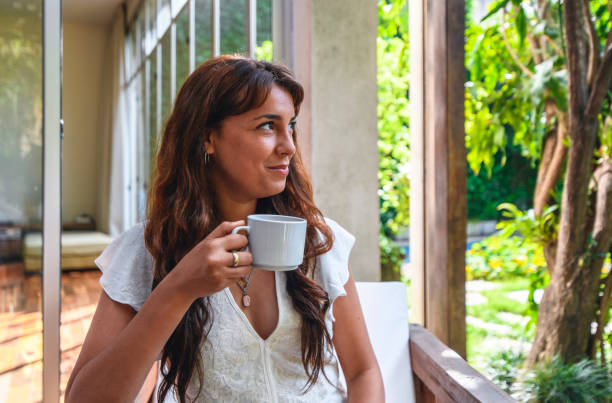 istock Young Hispanic Woman Enjoying Morning Coffee on Home Deck 1189350186