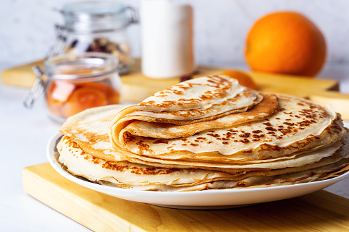 Thin pancakes on white rustic table