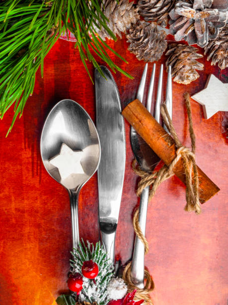 istock Christmas table place setting. Holidays Christmas menu concept over red background, with berries, rose hip, cones and branch with snow, white wooden star, cinnamon stick 1189355909