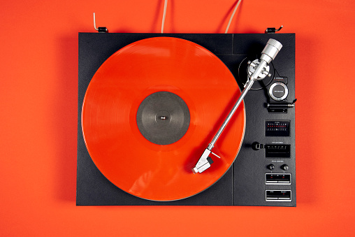 Colored vinyl records collection on a red background with copy space. Top view.