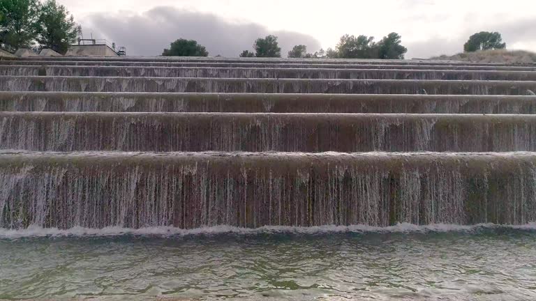 steps from waterfalls of canal water view drone going up step to road