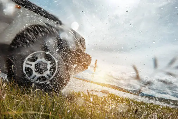 Photo of 4x4 car wheel and water splashes