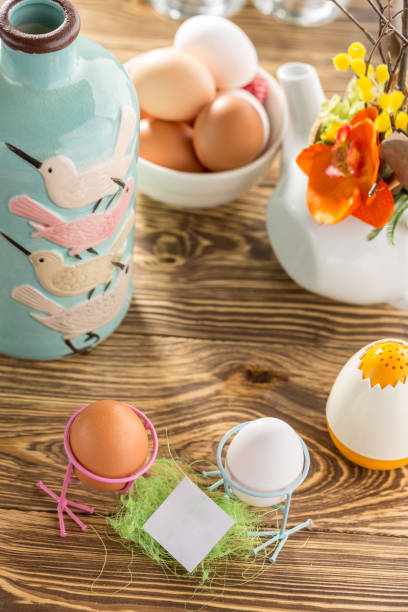 istock Easter mockup card With Easter Eggs On wooden Background for Seasonal Easter message with blue vase 1189360063