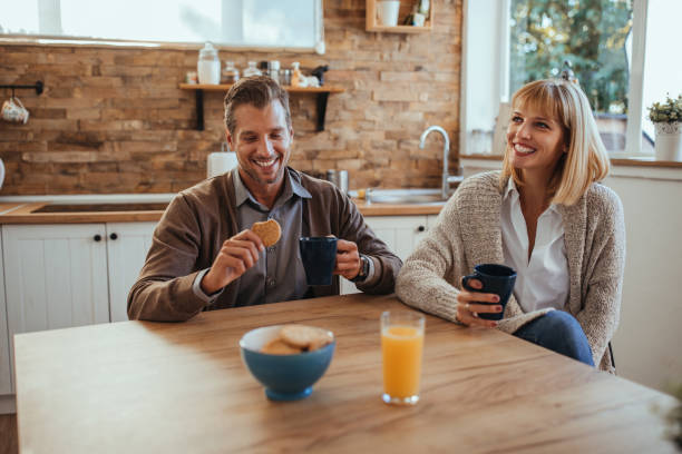 He makes her laugh Couple enjoying first morning coffee at home Petrovaradin stock pictures, royalty-free photos & images