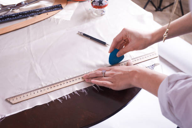 istock The seamstress makes a pattern for the future product. Sewing workshop. Woman engages in her favorite hobby of sewing. 1189368426
