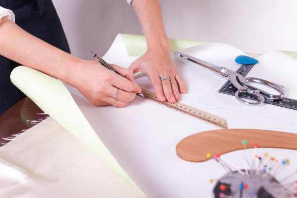 istock The seamstress makes a pattern for the future product. Sewing workshop. Woman engages in her favorite hobby of sewing. 1189368451