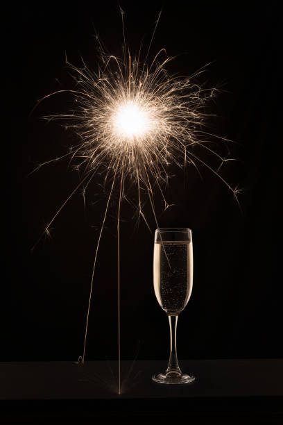 istock Champagne glass with lit sparkler against a dark background 1189368643
