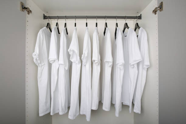 white shirts on hangers in a row