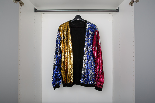 Wardrobe with a colorful sequin cardigan. Standing out from the crowd, individuality concept.