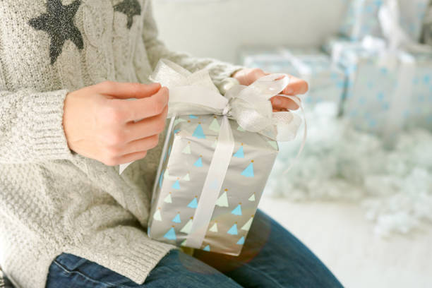 istock Christmas gift box in woman hands, silver celebration card 1189370878