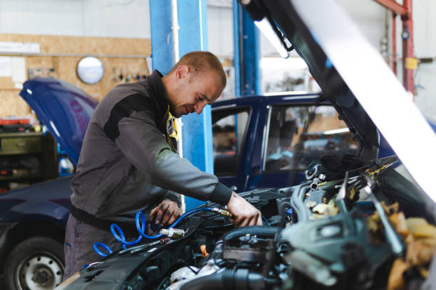 istock Handsome mechanic in uniform is working in auto service garage. Repair service. 1189374054