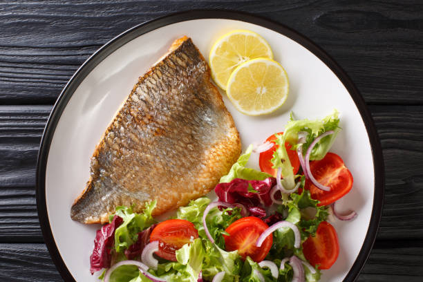 istock Main dish fried dorada fillet with vegetable salad close-up on a plate. Horizontal top view 1189374323