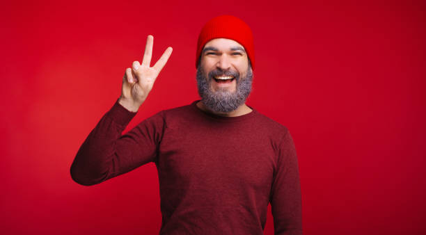 istock Portrait of handsome bearded man with white beard showing PEACE gesture 1189376119