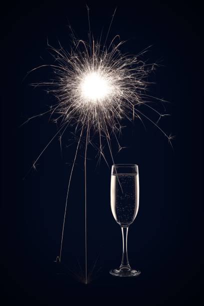 istock Champagne glass with lit sparkler against a dark background 1189376726