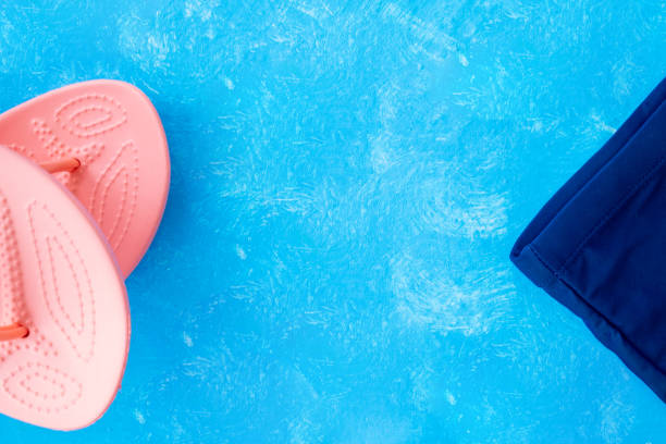 istock pink coral flip flops on blue textured background 1189377018