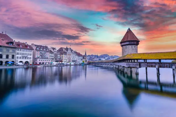 Long exposure shot of Lucerne historic Capel Bridge during sunset with colorful sky