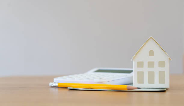 istock close up front view on home model with yellow pencil, banking account and calculator at table for money management ,home loan and personal financial concept 1189377633