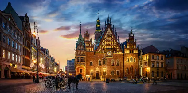 Photo of Wroclaw central market square with old houses, Town Hall and sunset, horse and carriage.